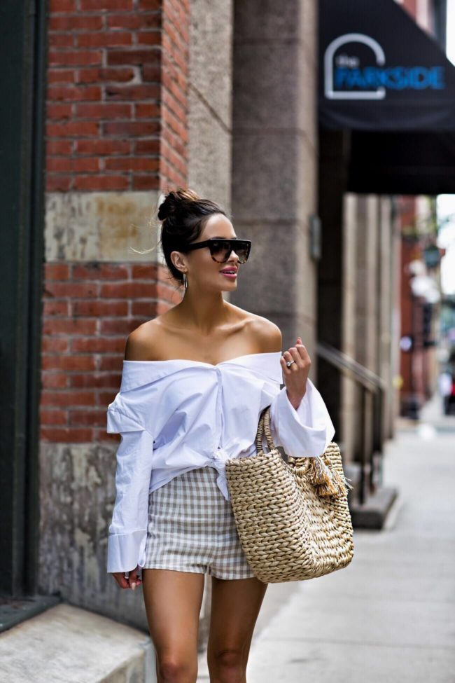 fashion blogger mia mia mine wearing a white button down shirt and gingham shorts from revolve