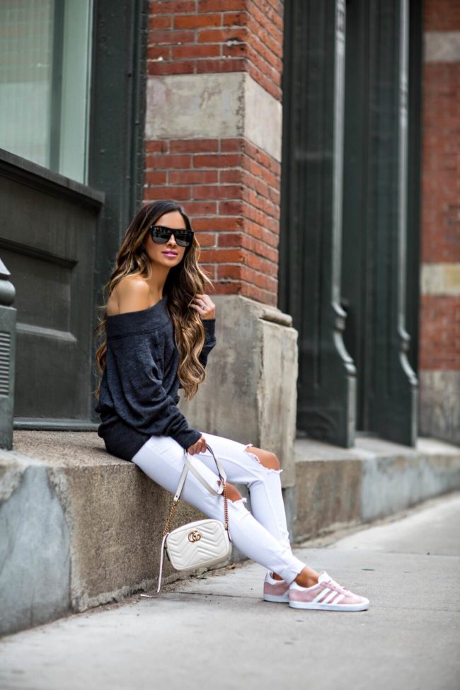 fashion blogger mia mia mine wearing a gray off shoulder sweater from macy's and pink adidas sneakers