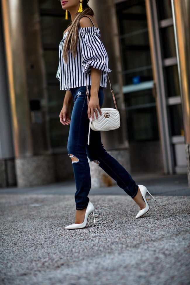 fashion blogger mia mia mine wearing a black and white striped top and frame denim jeans