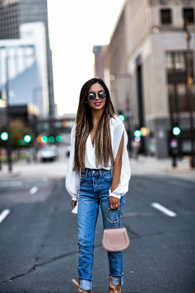 fashion blogger mia mia mine wearing a white bodysuit and levi's jeans from revolve