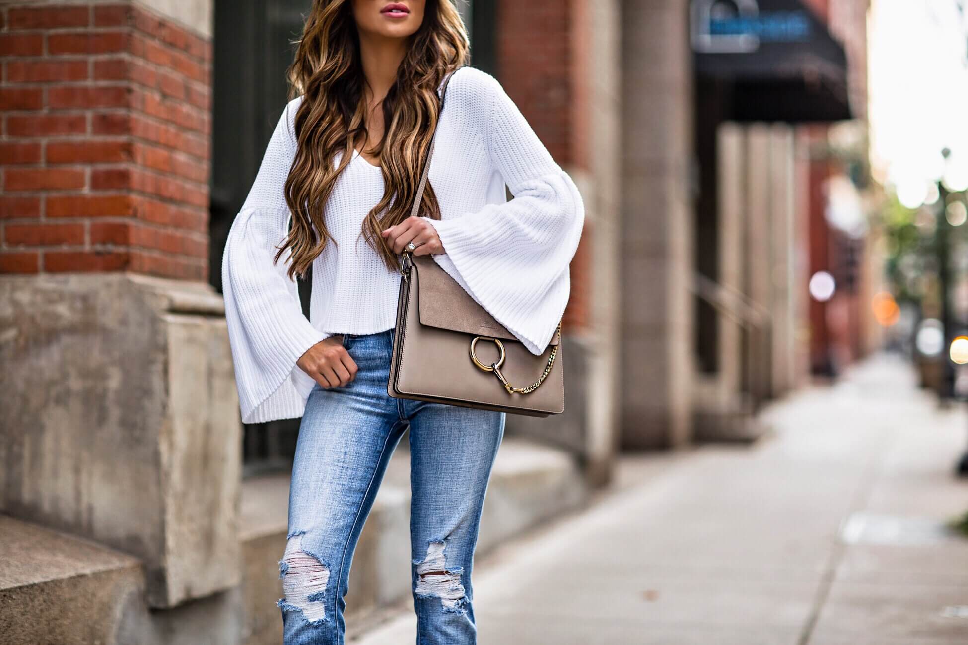 fashion blogger mia mia mine wearing a white bell sleeve sweater by free people