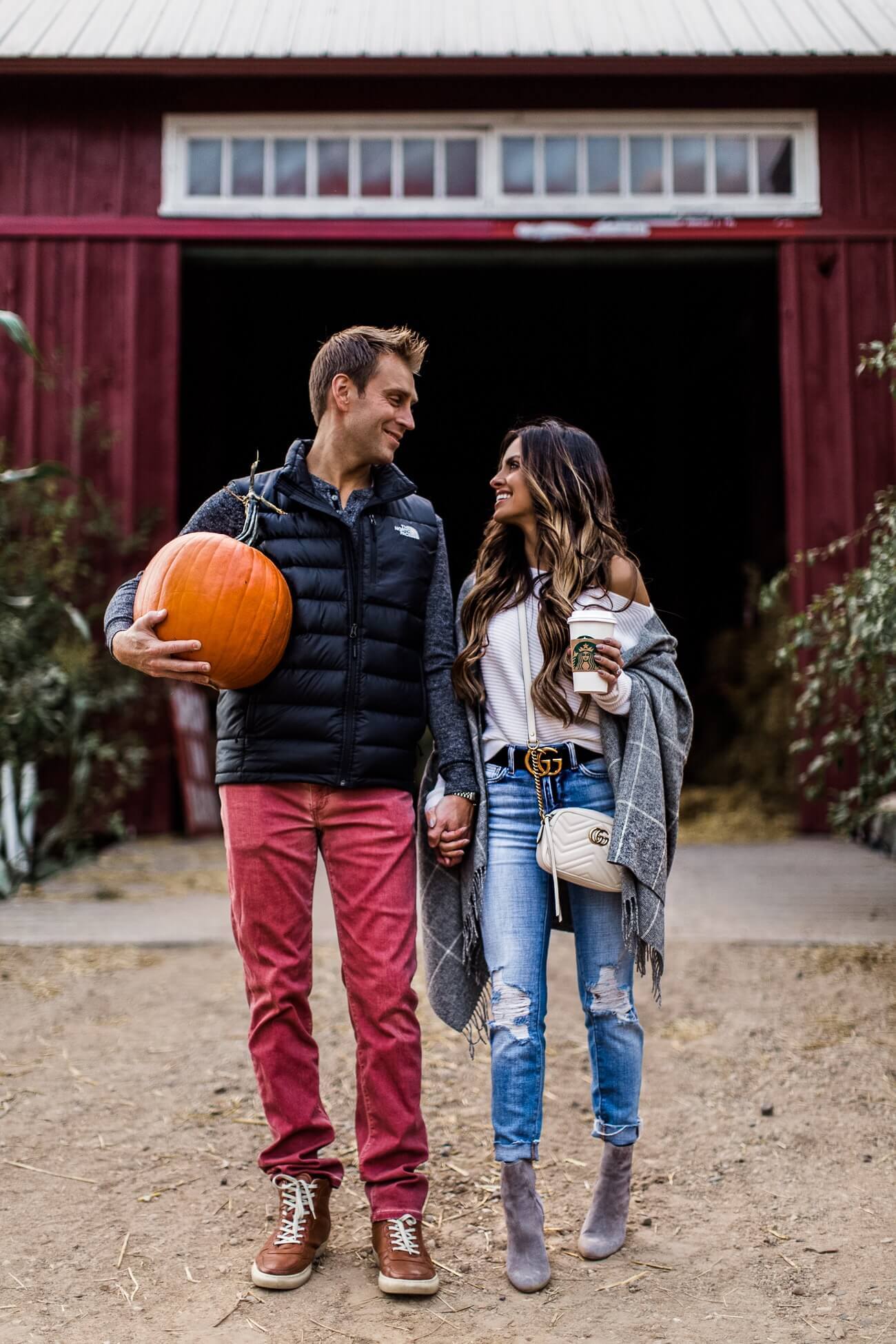 mia mia mine wearing a plaid wrap at a pumpkin path with husband