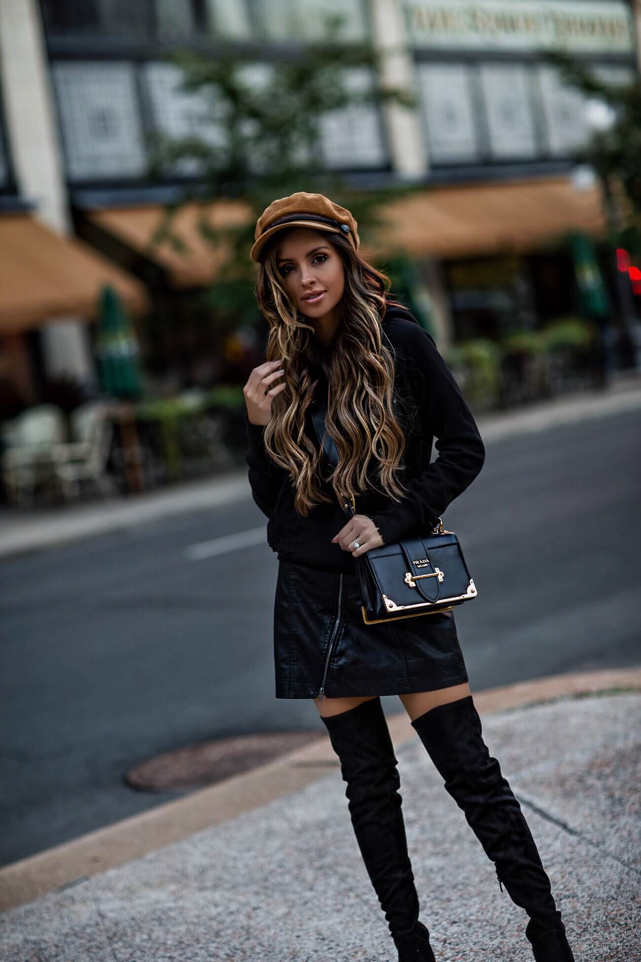 fashion blogger mia mia mine wearing a baker boy hat and a black hooded sweatshirt