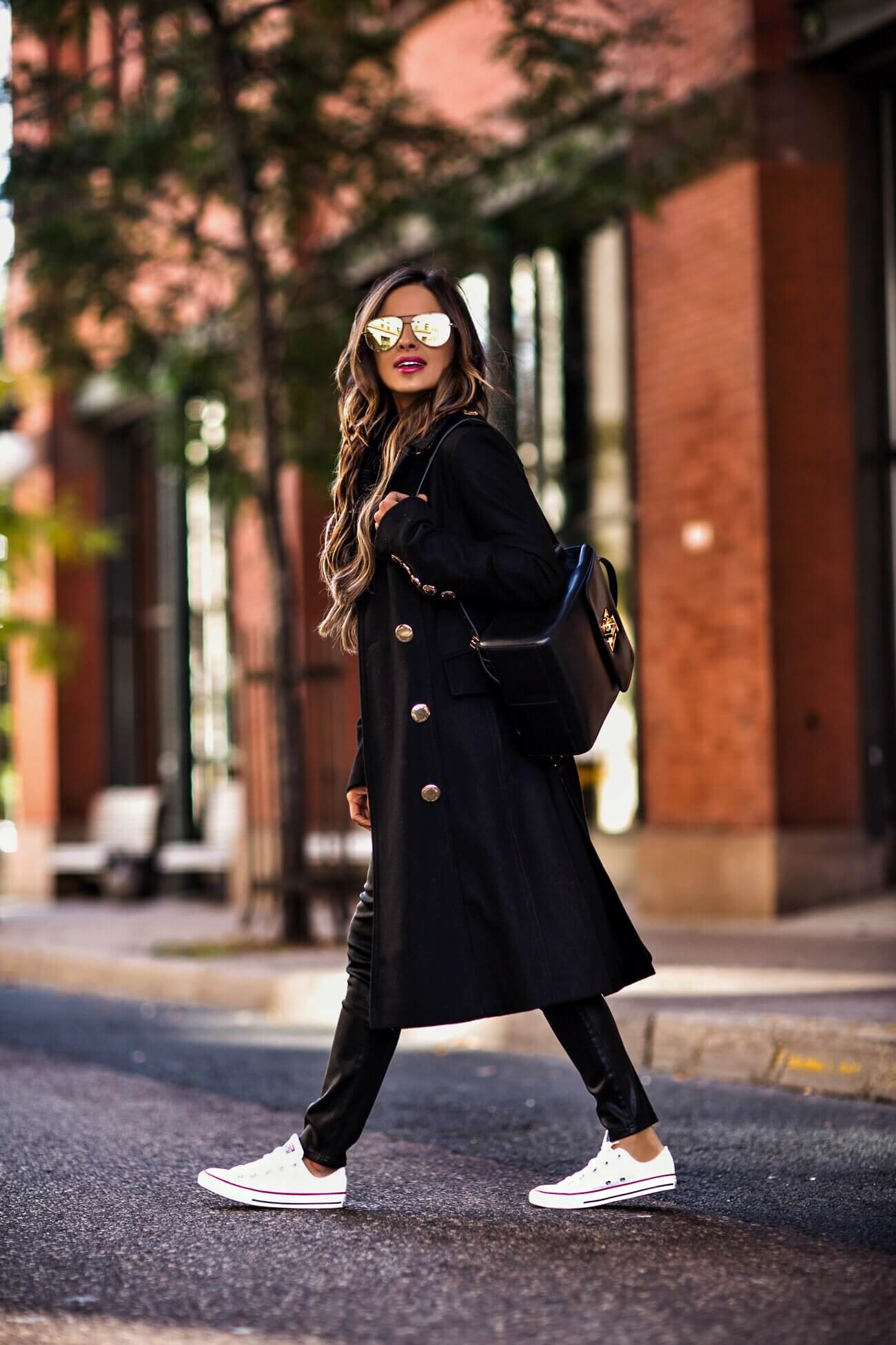 fashion blogger mia mia mine wearing a black coat from macy's and a tommy backpack