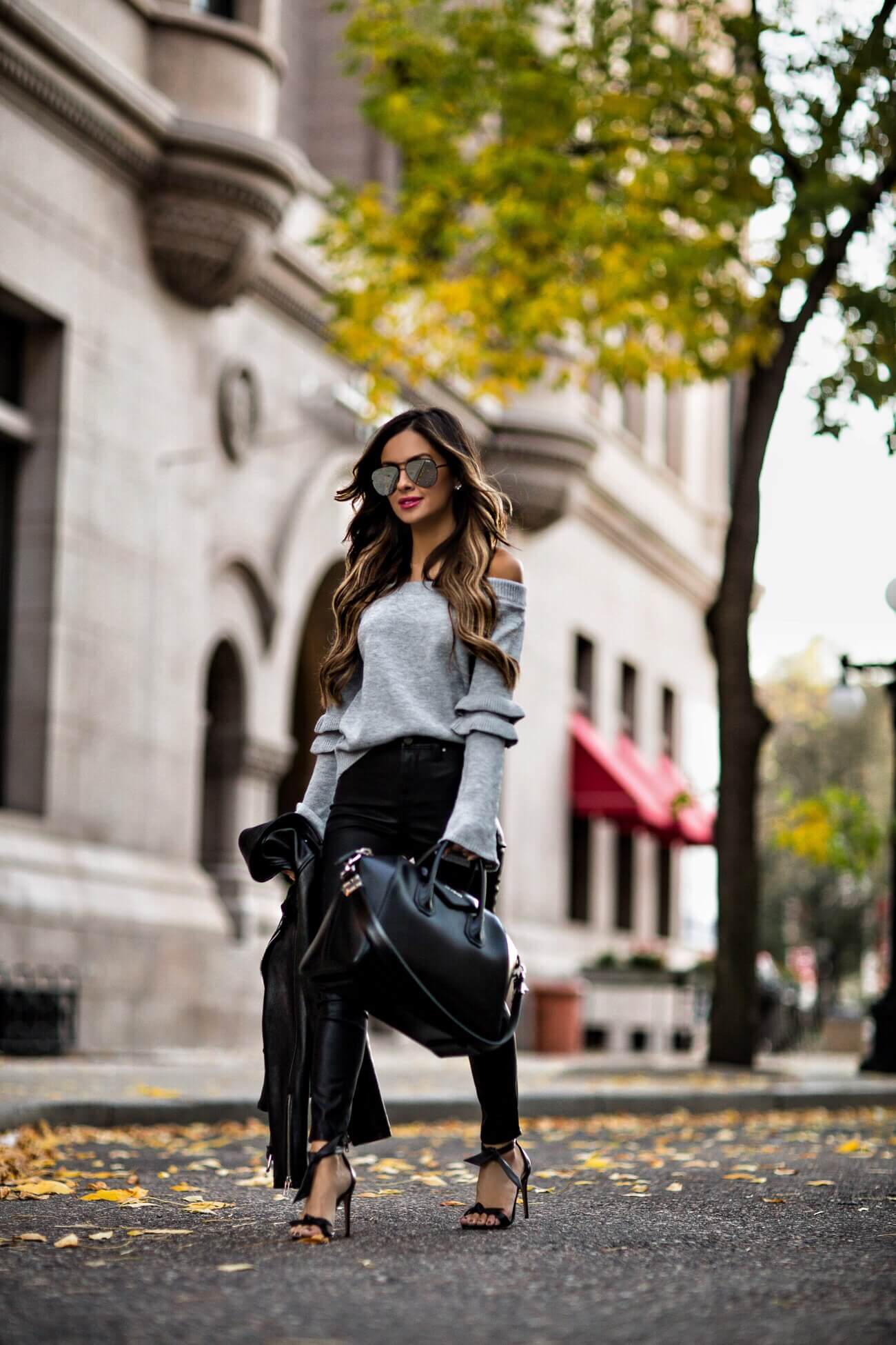 fashion blogger mia mia mine wearing a gray off-the-shoulder sweater and black blank nyc pants