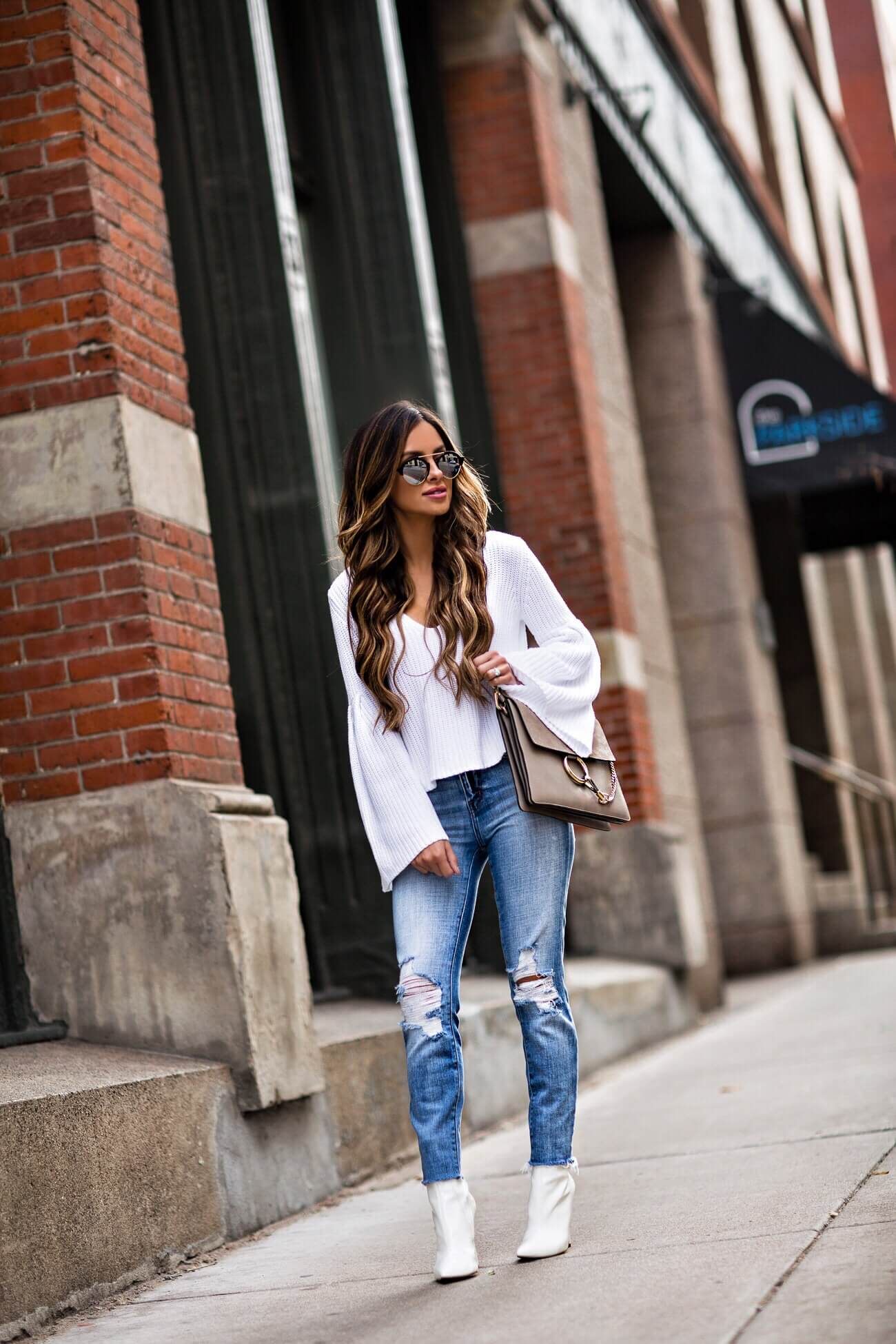 fashion blogger mia mia mine wearing a white sweater and l'agence denim from intermix