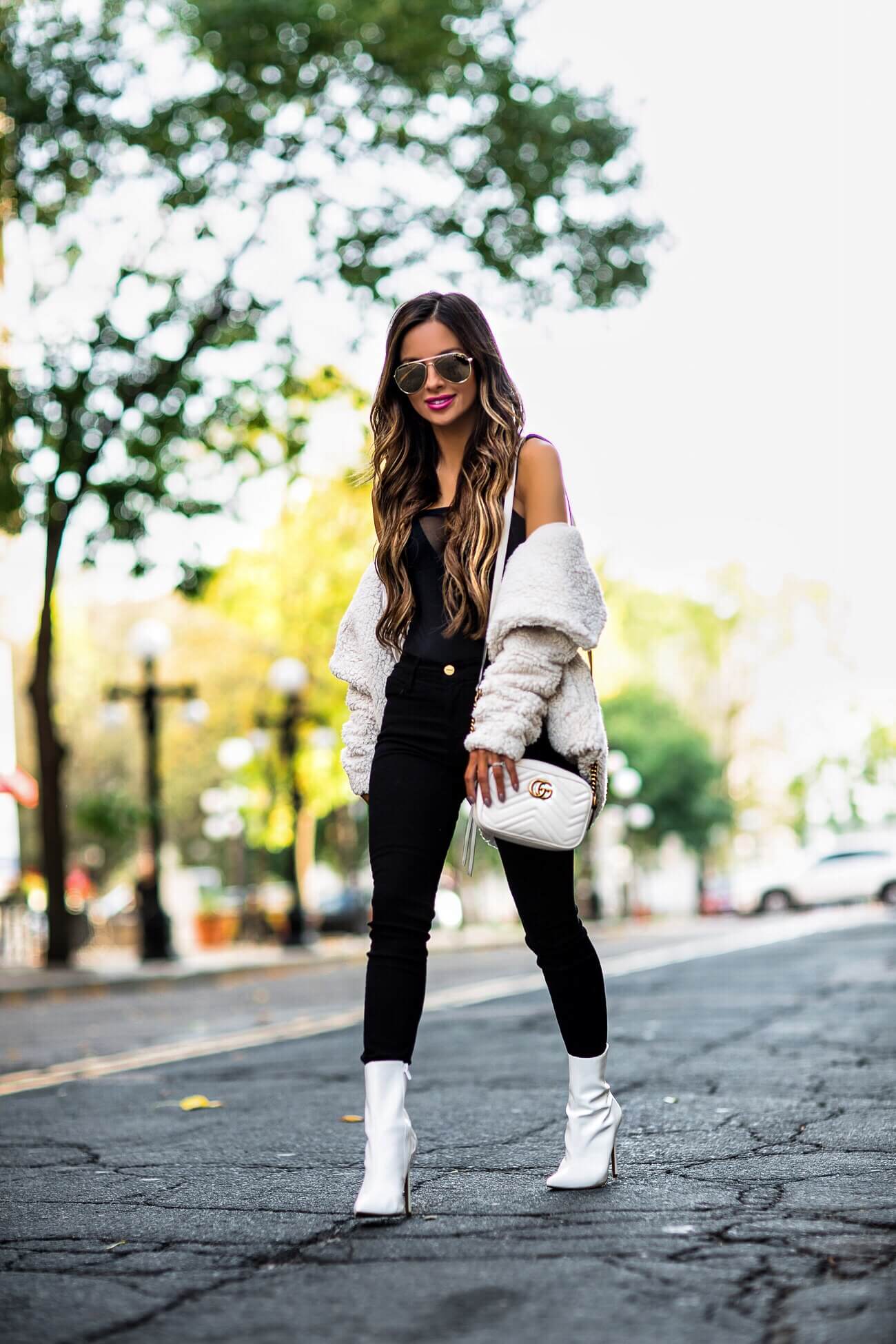 fashion blogger mia mia mine wearing a white teddy bear coat and white steve madden booties