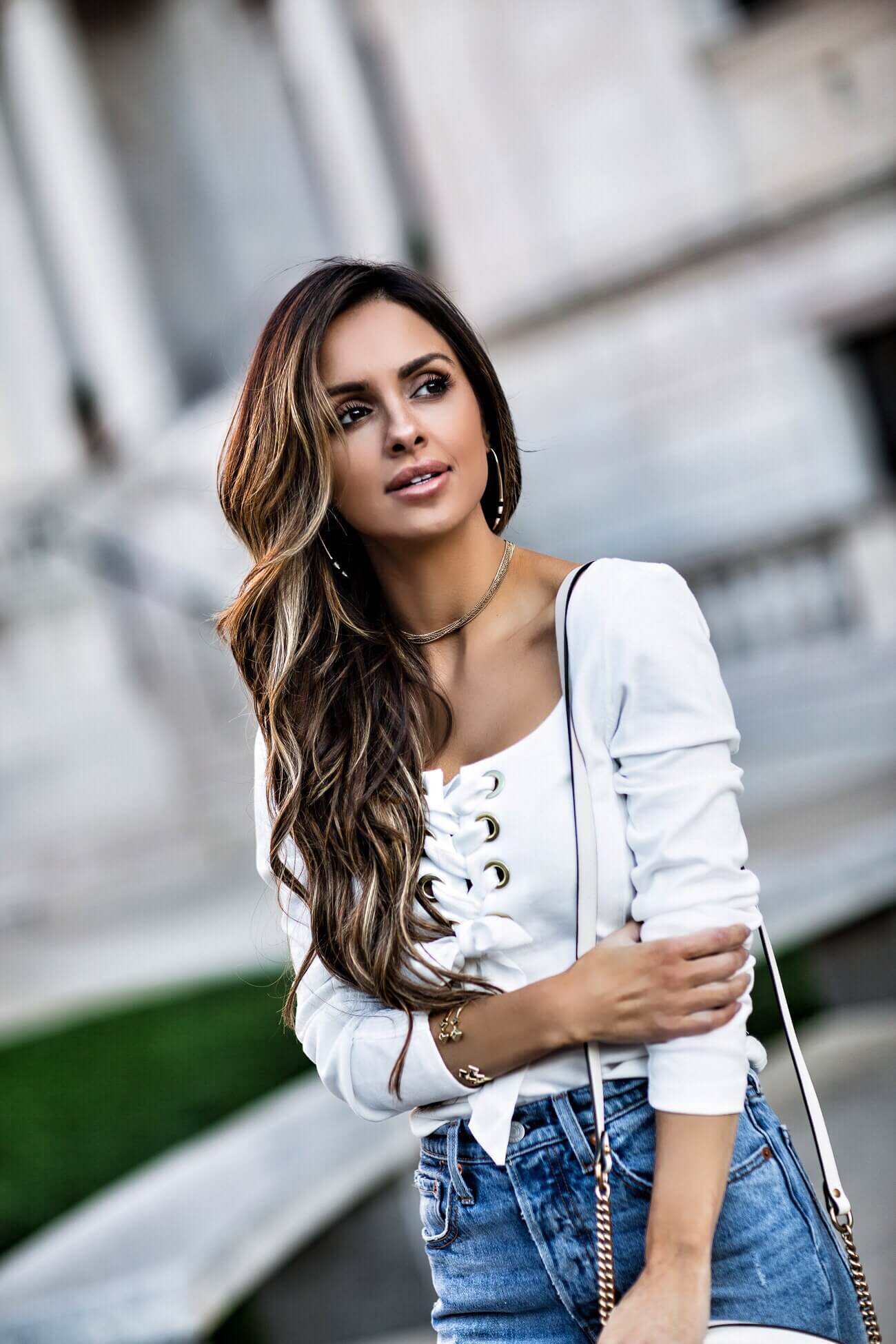 fashion blogger mia mia mine wearing a white lace-up free people top and gold jewelry from rocksbox