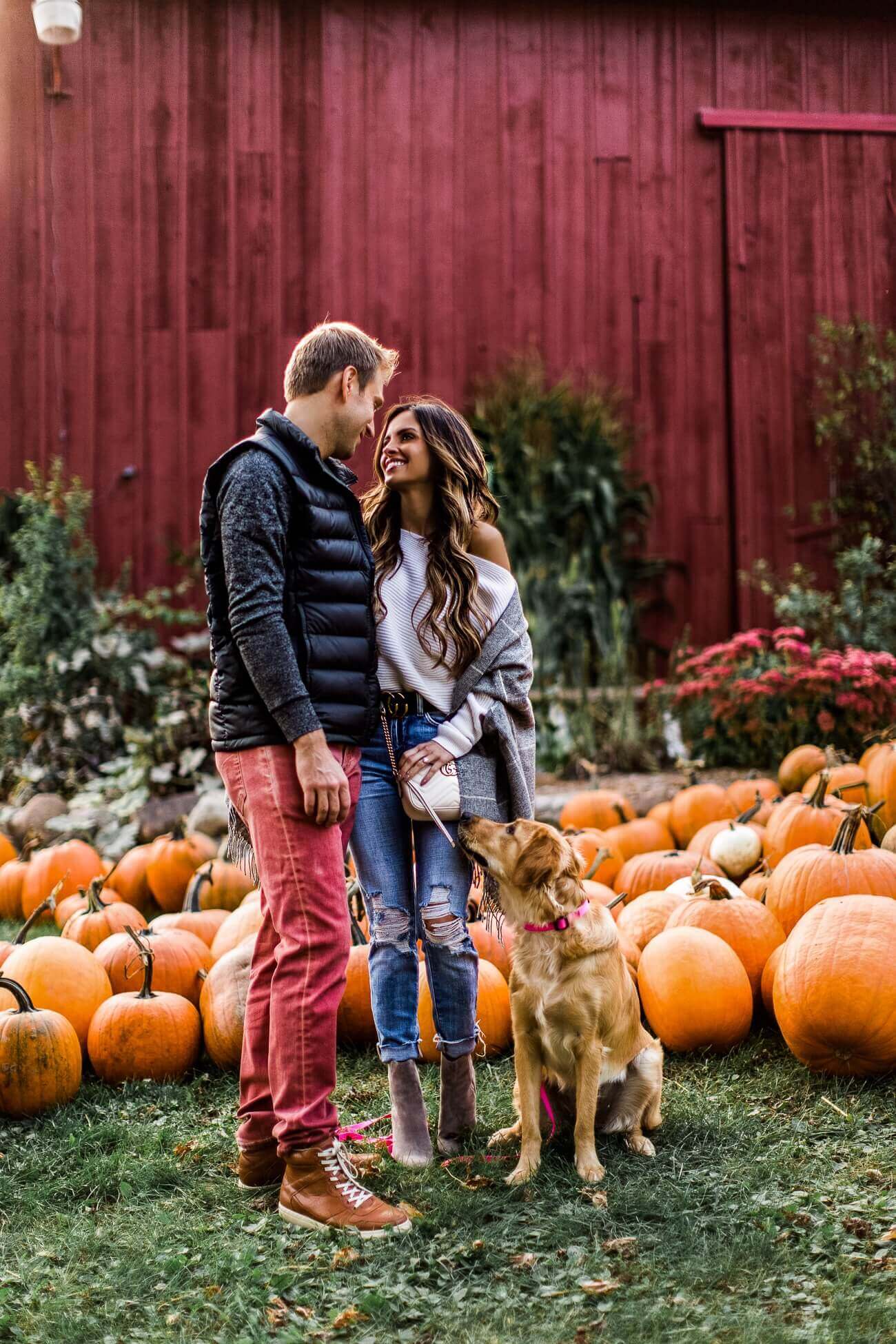 fashion blogger at a pumpkin patch with husband and golden retriever