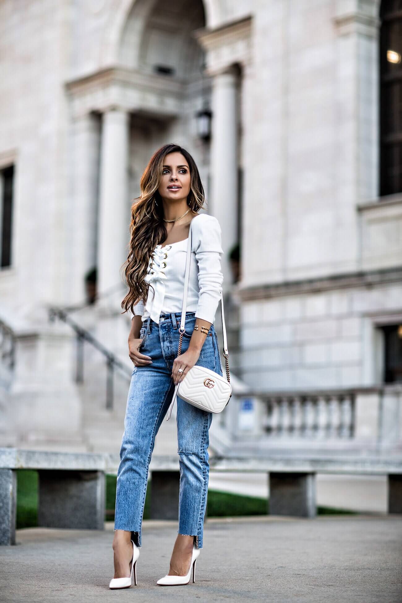 fashion blogger mia mia mine wearing a white lace-up top from free people and levi's jeans
