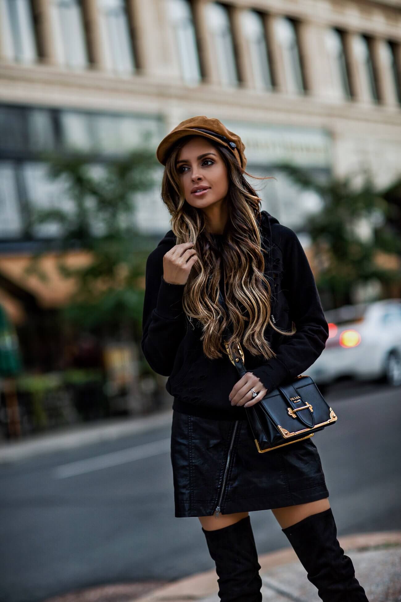 fashion blogger mia mia mine wearing a prada cahier bag and baker boy hat 
