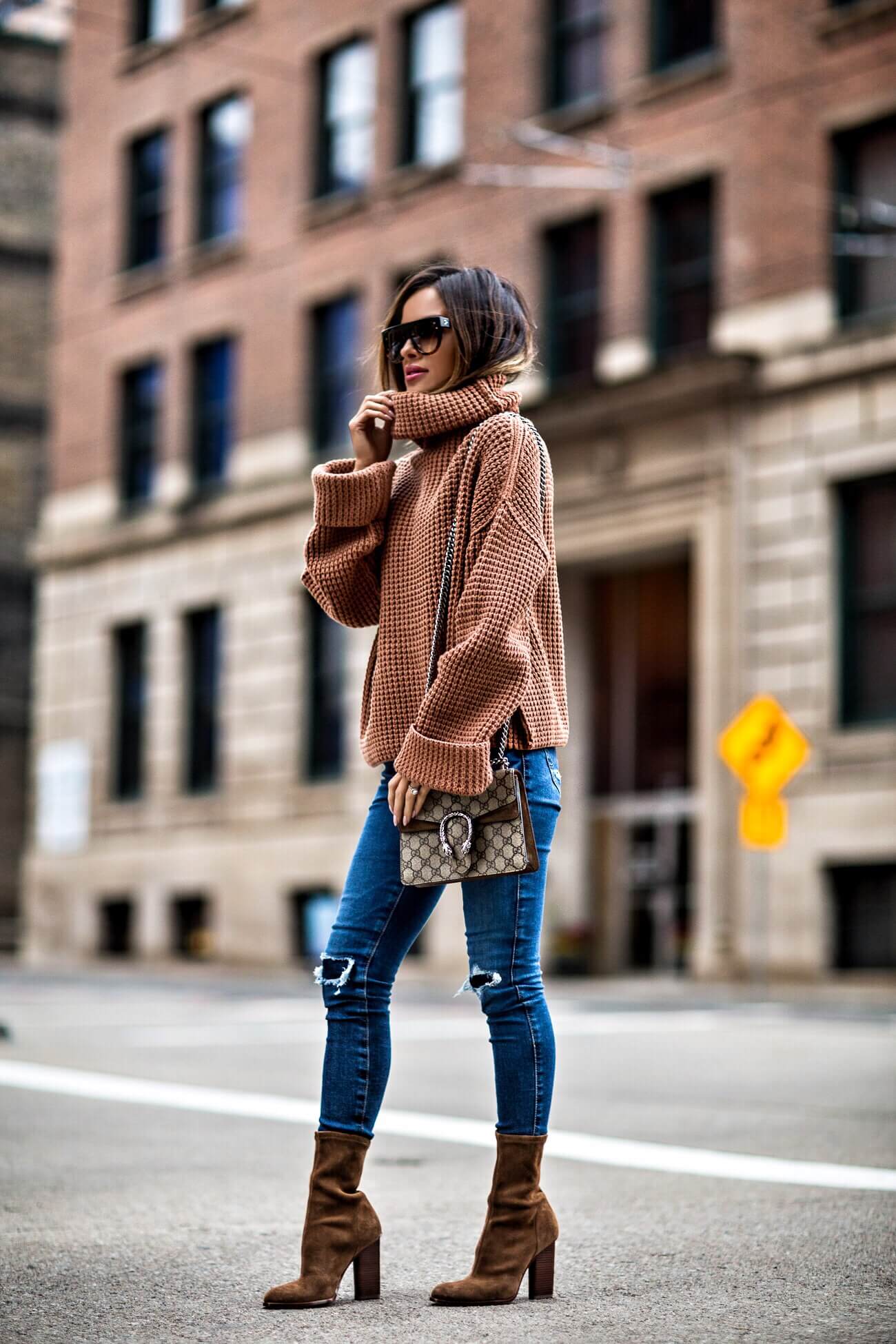 fashion blogger mia mia mine wearing an orange sweater and ag jeans