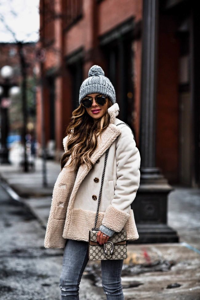 fashion blogger mia mia mine wearing a gray beanie and gucci dionysus bag and mother jacket from bloomingdale's