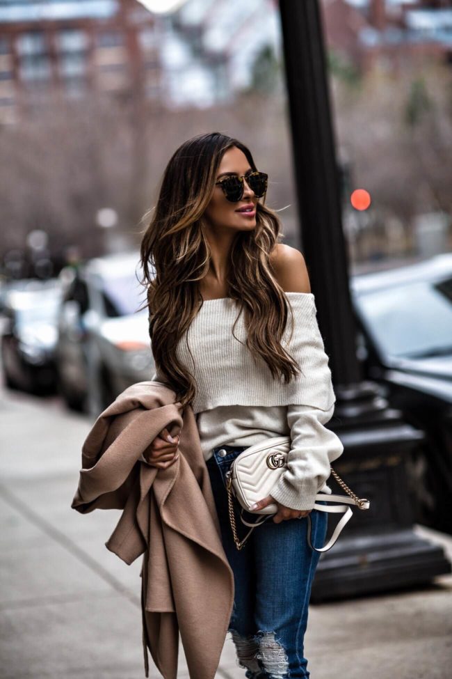 fashion blogger mia mia mine wearing a white sweater and karen walker sunglasses