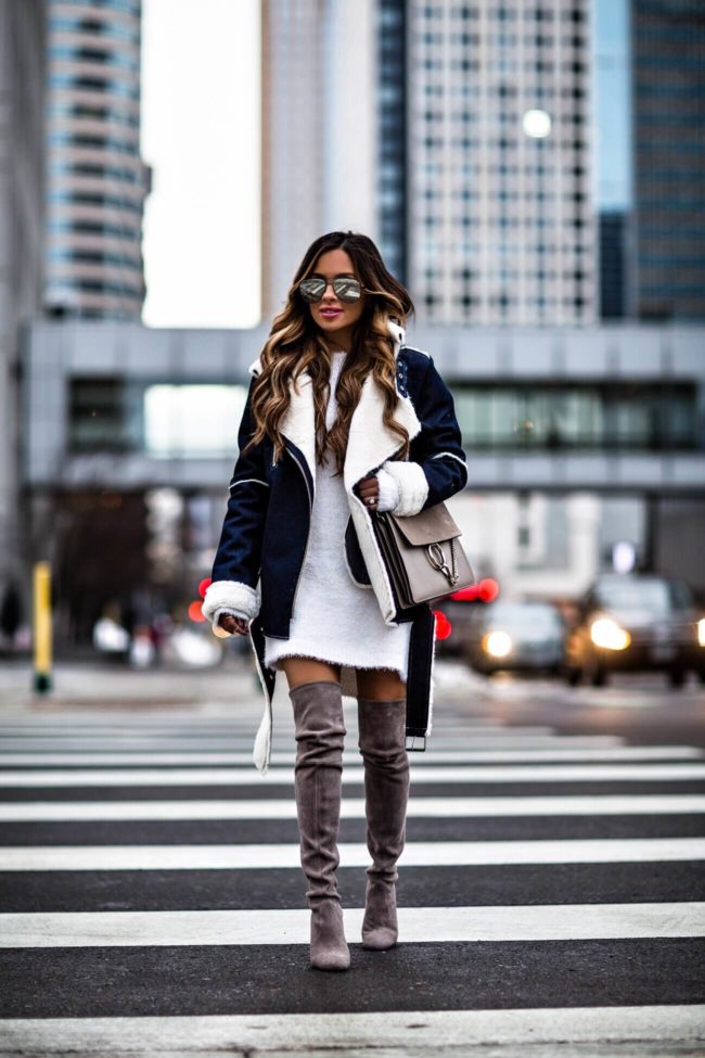 fashion blogger mia mia mine wearing a white sweater dress from bloomingdales and stuart weitzman over-the-knee boots 