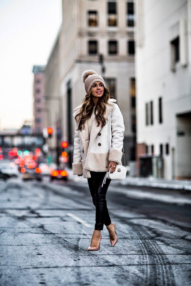 fashion blogger mia mia mine wearing a sherpa jacket and pom pom beanie