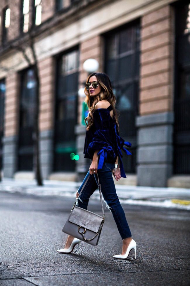 fashion blogger mia mia mine wearing a blue velvet top and chloe faye bag