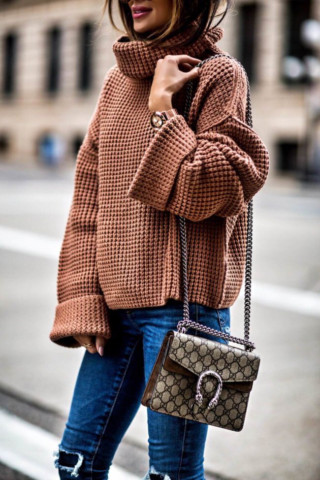 fashion blogger mia mia mine wearing a chunky knit sweater and gucci crossbody bag