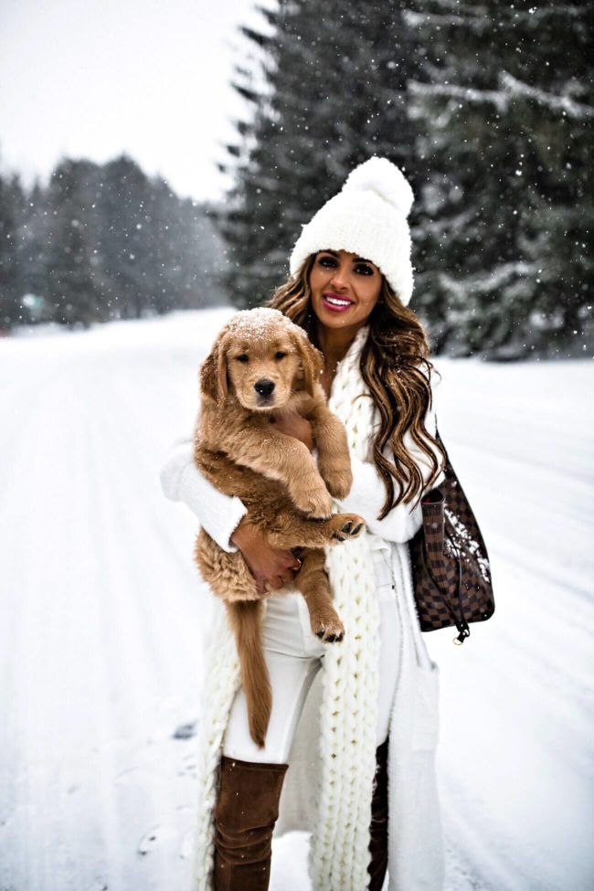 fashion blogger mia mia mine wearing a white free people beanie hat with golden retriever puppy