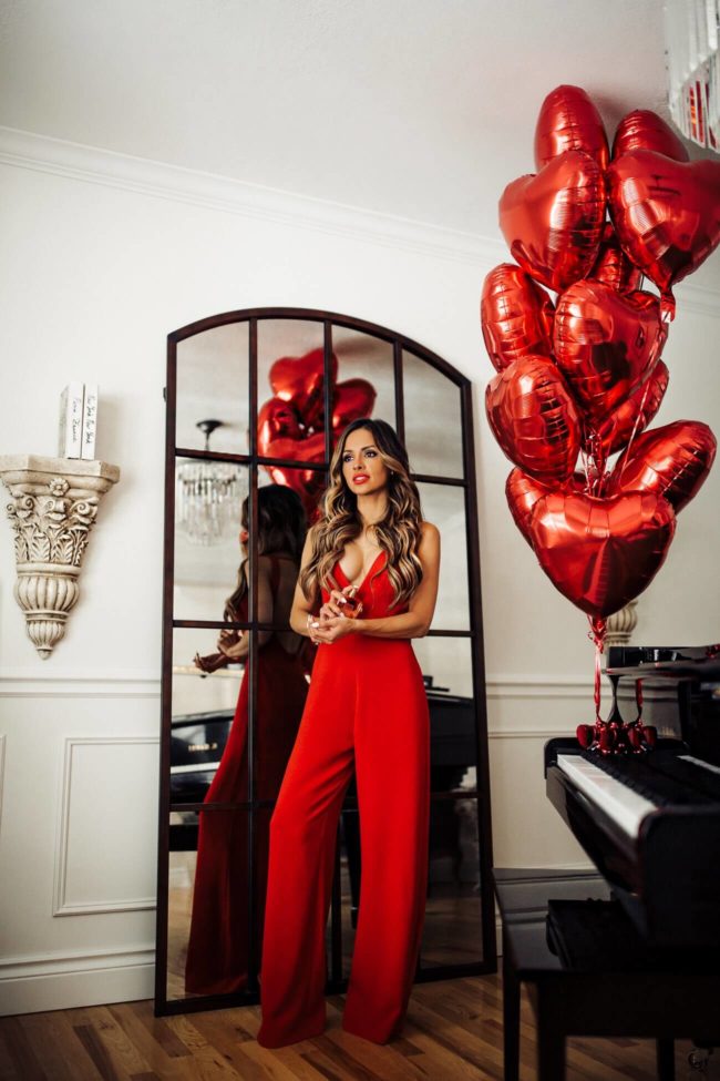 fashion blogger mia mia mine wearing a red jumpsuit from nordstrom at home