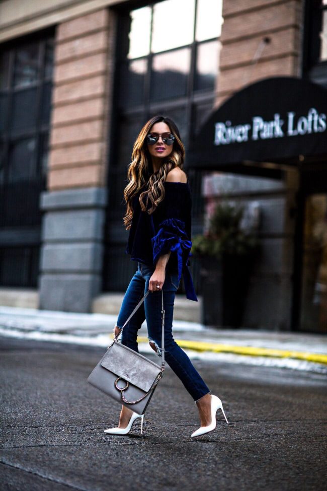 fashion blogger mia mia mine wearing a blue velvet top and levi's denim