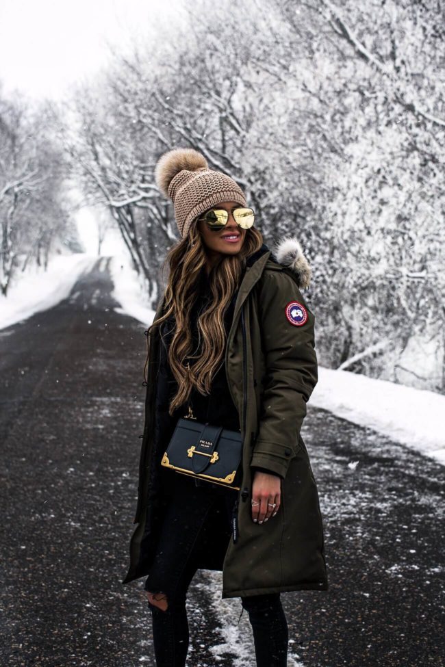 fashion blogger mia mia mine wearing a canada goose parka and a prada cahier bag
