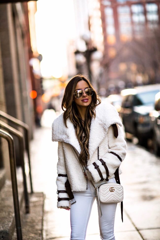 fashion blogger mia mia mine wearing a white sherpa jacket and a gucci mini dionysus