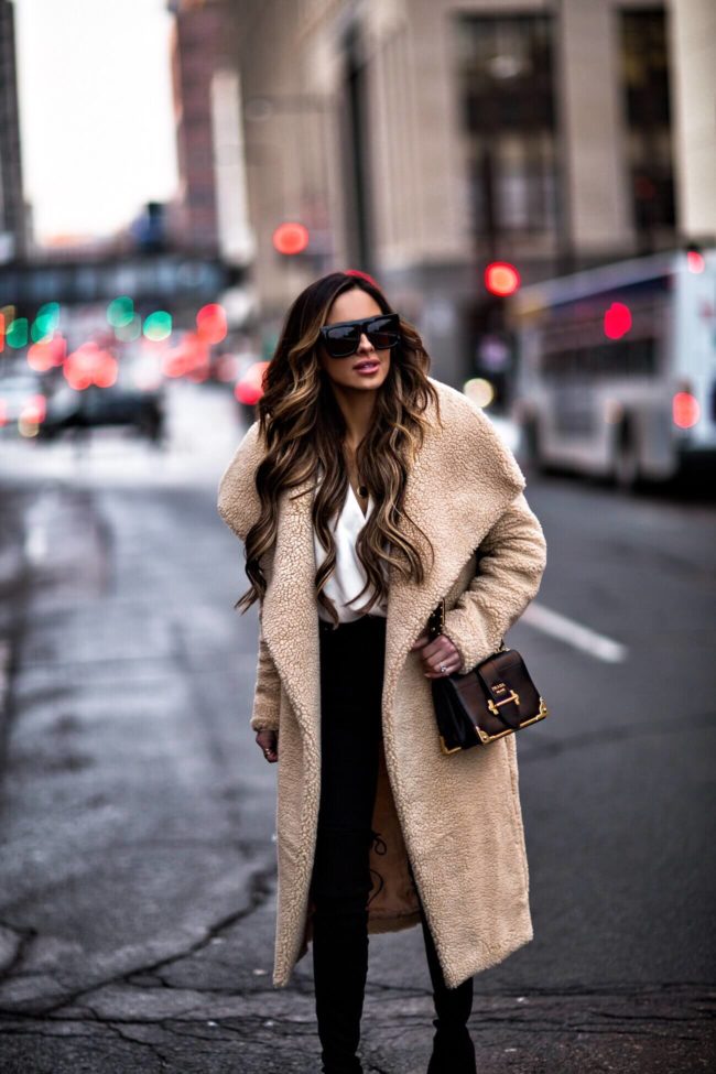 fashion blogger mia mia mine wearing a teddy bear coat and a prada cahier bag