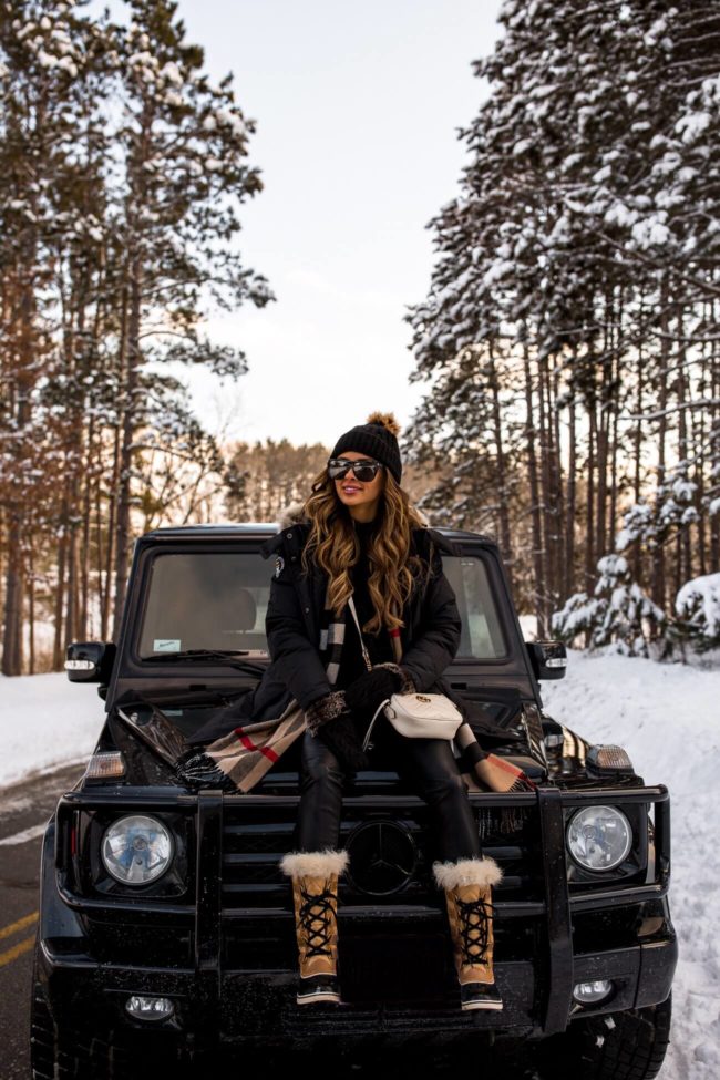 fashion blogger mia mia mine wearing a burberry scarf with a mercedes g wagon