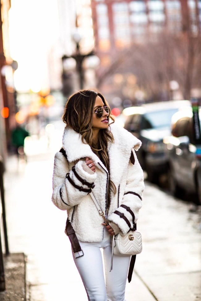 fashion blogger mia mia mine wearing an eaves shearling jacket and white denim