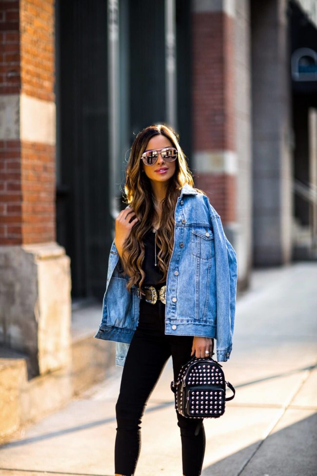 fashion blogger mia mia mine wearing a double buckle belt and a denim jacket from missguided