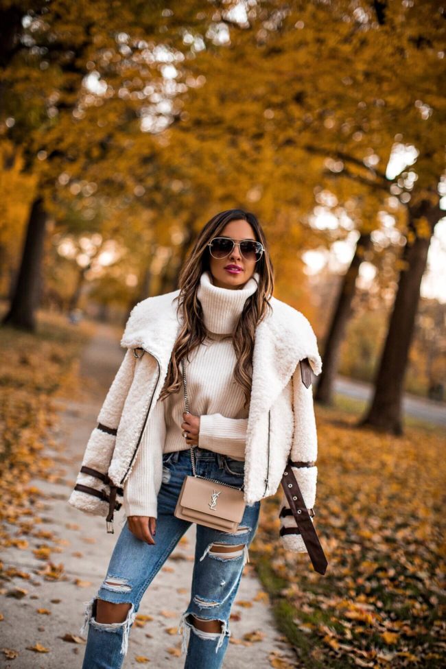 fashion blogger mia mia mine wearing a sherpa jacket from revolve and a saint laurent sunset bag