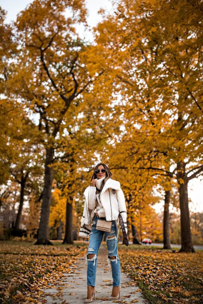 fashion blogger mia mia mine wearing a sherpa jacket and distressed grlfrnd denim from revolve