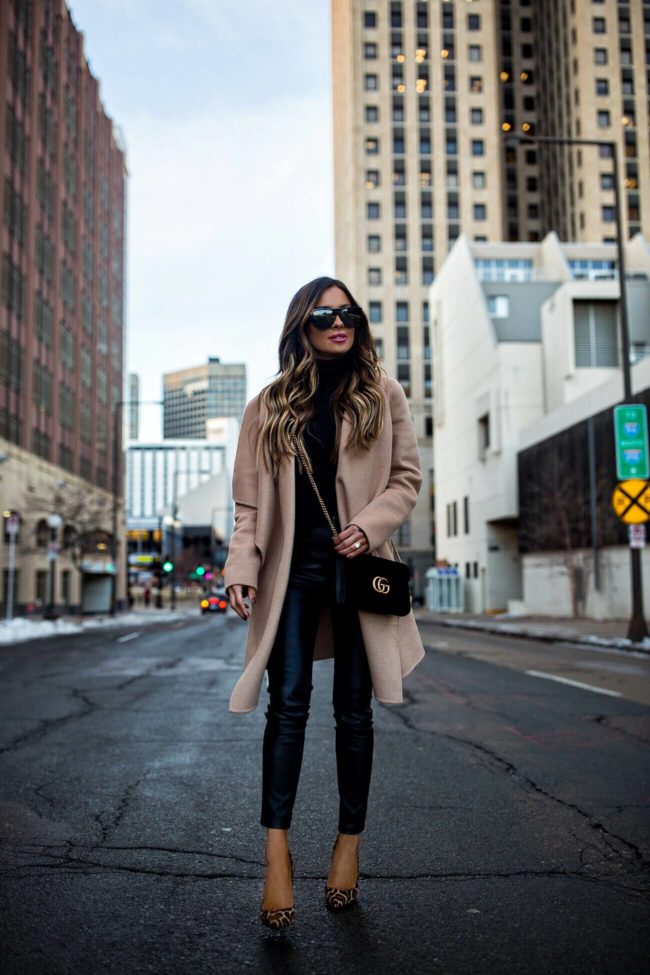 fashion blogger mia mia mine wearing a camel coat and all black outfit for winter 2019