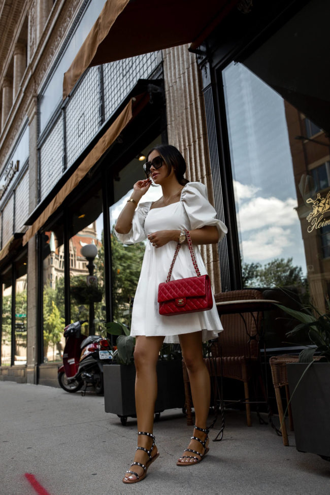 fashion blogger wearing a white summer dress and studded sandals from walmart