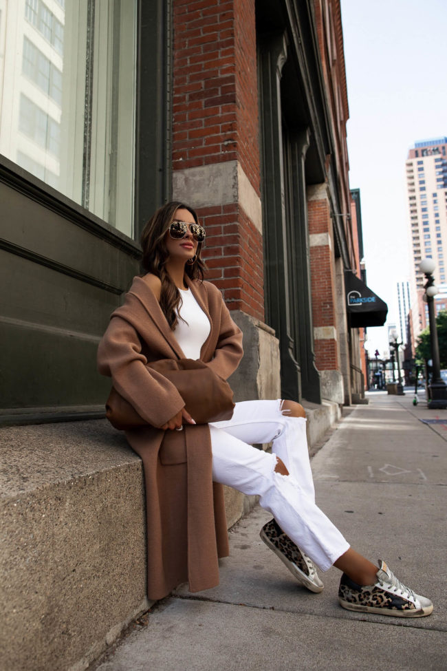 fashion blogger wearing leopard golden goose superstar sneakers and a white outfit