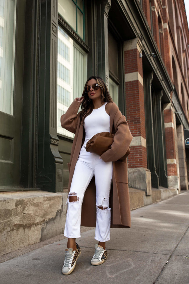 brunette fashion blogger wearing a camel coat and bottega veneta the pouch bag