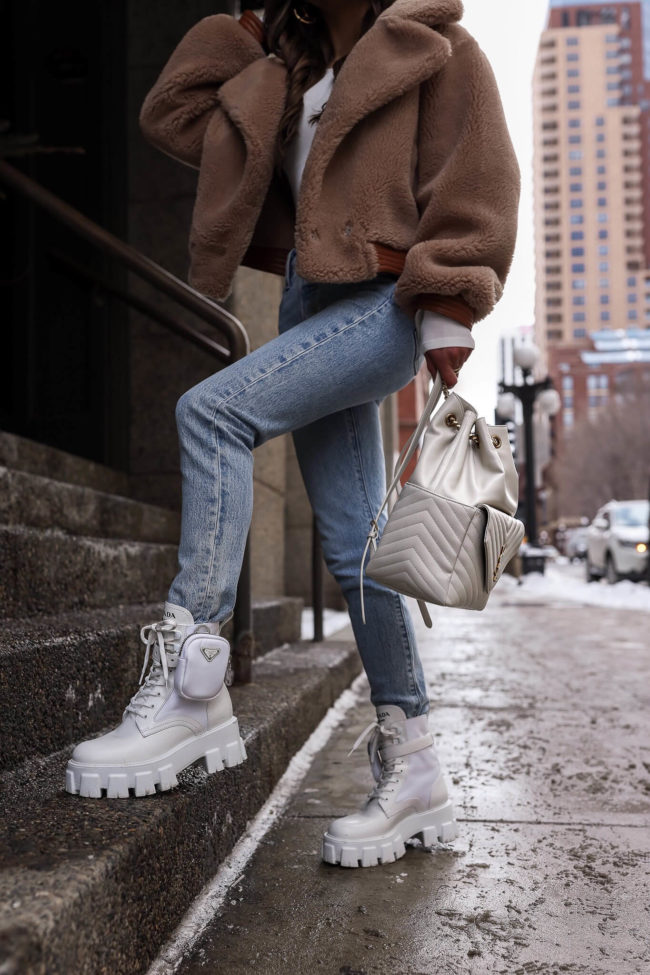 fashion blogger wearing levi's jeans and white prada boots
