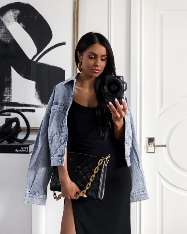 fashion blogger mia mia mine wearing a denim jacket and a black dress from abercrombie