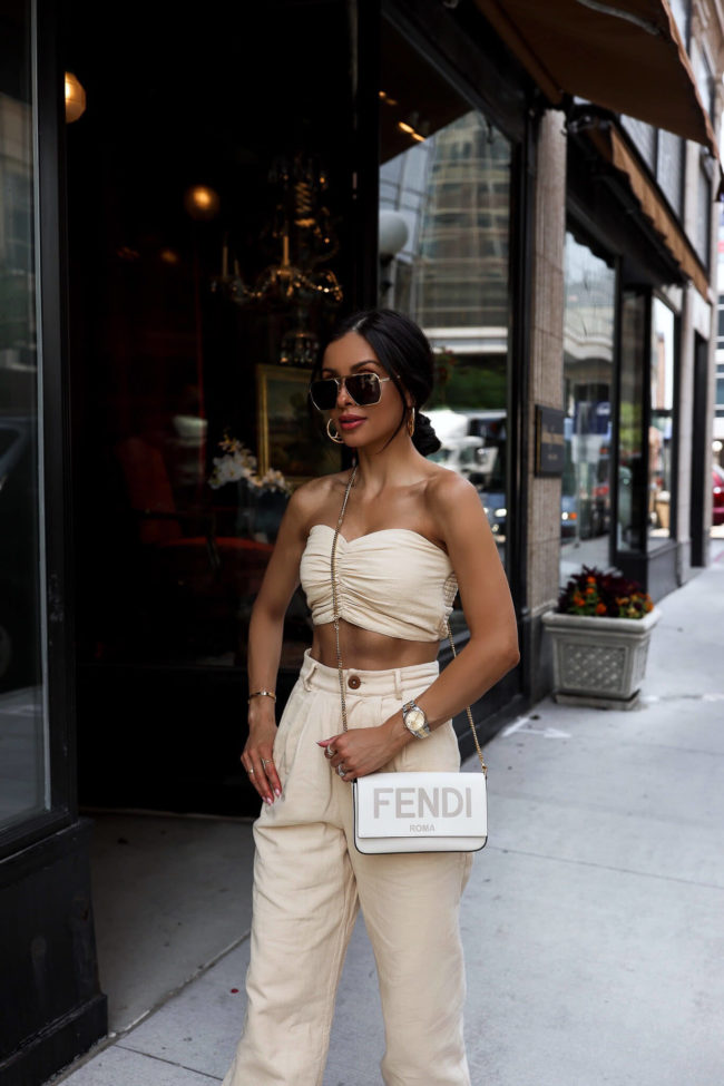 fashion blogger mia mia mine wearing a cream matching set with a fendi crossbody bag
