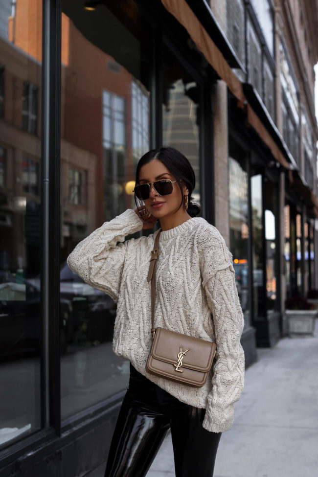 fashion blogger mia mia mine wearing a cable knit sweater by free people