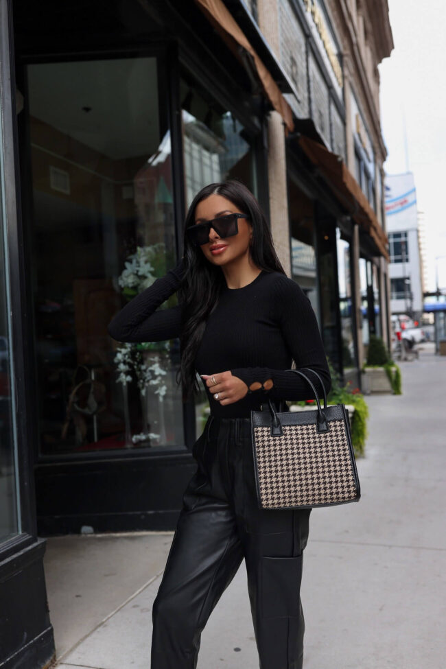 woman wearing a black outfit with a houndstooth bag from walmart