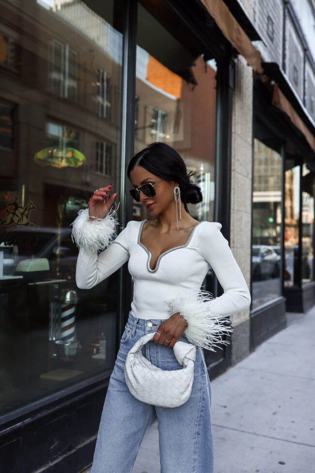 fashion blogger wearing a self-portrait white feather sweater and agolde denim from saks