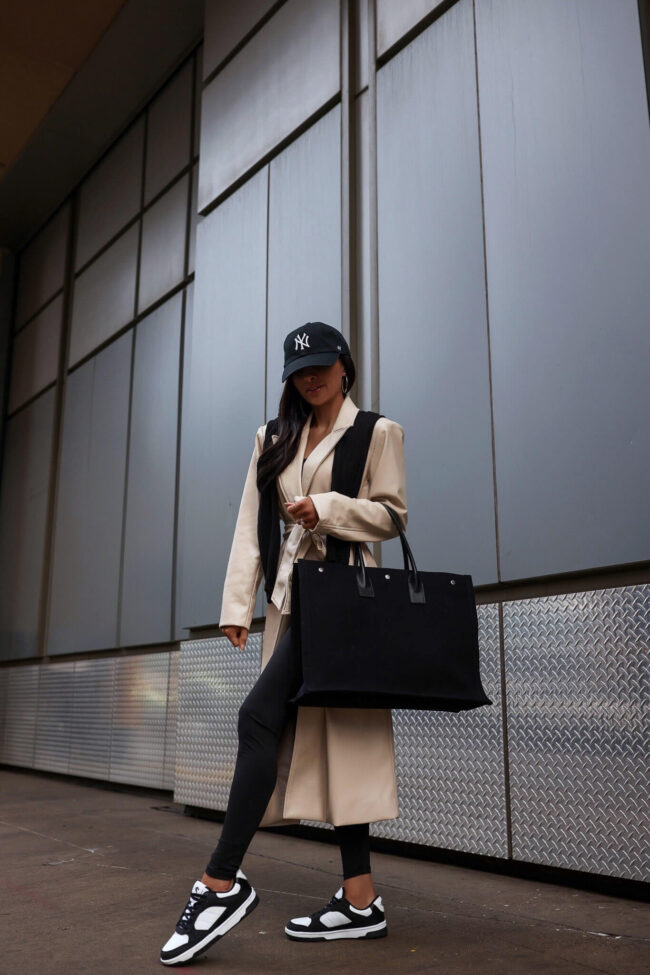 fashion blogger mia mia mine wearing a camel trench coat and sneakers for spring