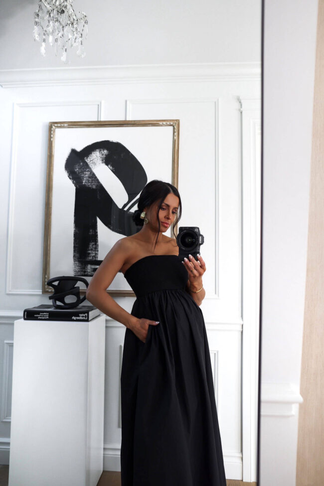 fashion blogger wearing a black maxi dress with pockets 