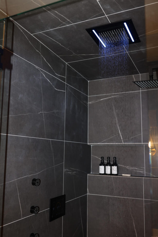 ThermaSol steam shower with rainfall shower head and dark stone tile
