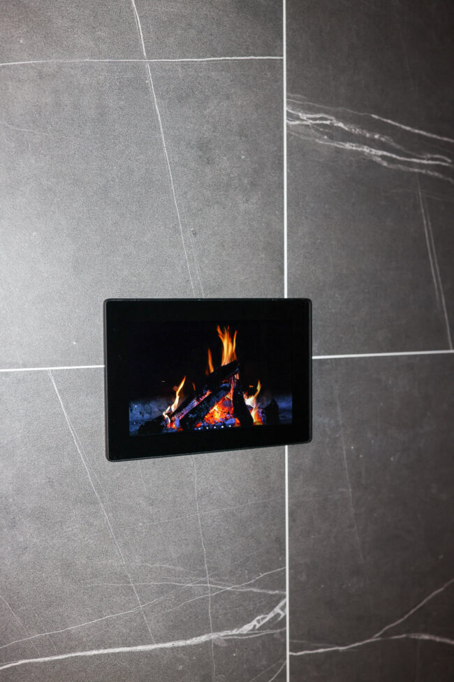 ThermaSol steam shower touchscreen built into dark stone shower wall