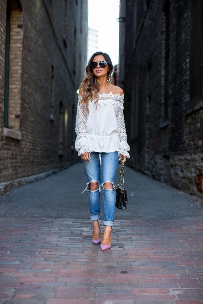 Maria Vizuete wearing levi's jeans and a lace off-the-shoulder-top in an alley