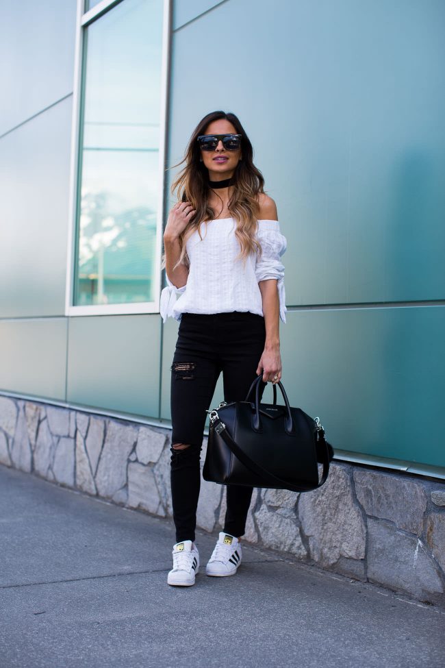 fashion blogger mia mia mine in a white off-the-shoulder top and givenchy bag
