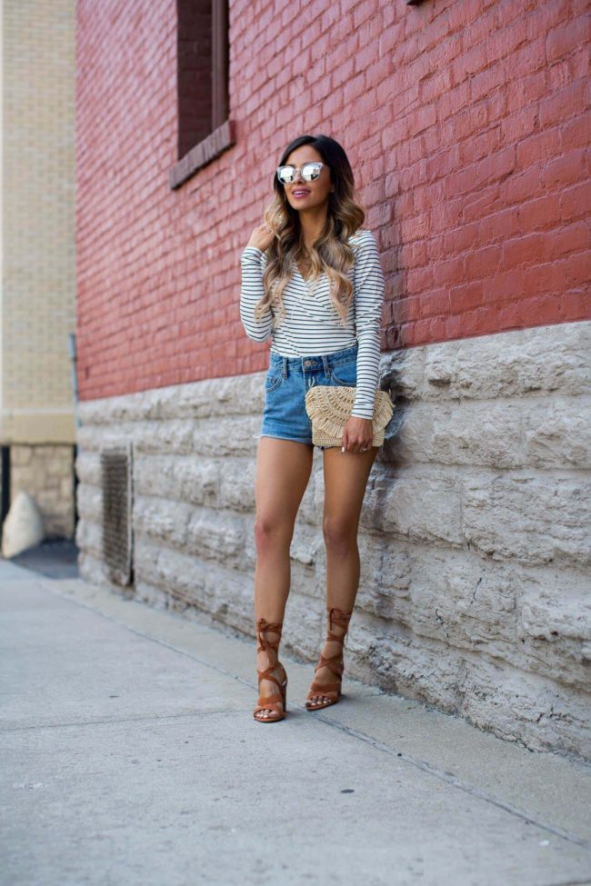 fashion blogger mia mia mine wearing a striped top and jean shorts from urban outfitters 